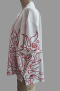 A white short-sleeve button-up shirt with red line-art flame or wave patterns, displayed on a mannequin torso against a plain beige wall.